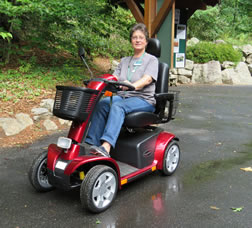 Visitor Services Associate Denise Moulis shows a mobility scooter.