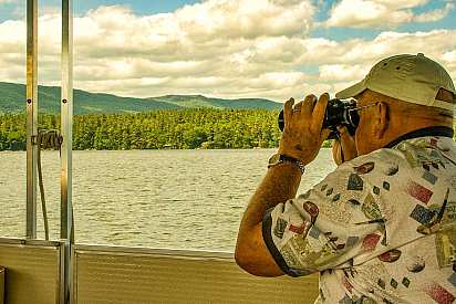 Viewing wildlife through binoculars on a Squam Lake Cruise